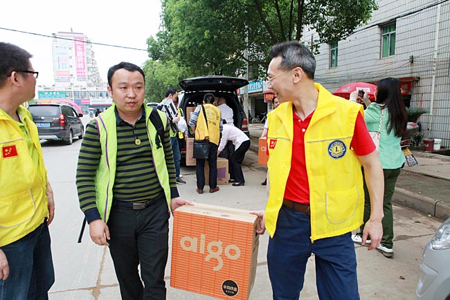 狮兄们将捐赠的电脑等物资搬下车